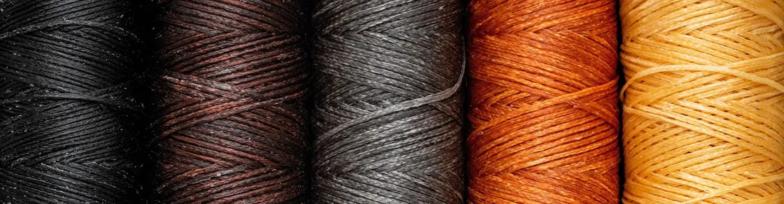 Bobinas de hilo encerado en negro, marrón, gris, naranja y amarillo